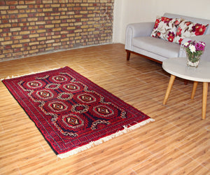 Vintage Baluchi Persian rug 110x195 cm styled in interior setting showing rich red geometric design
