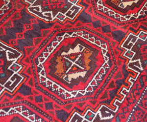 Corner detail of vintage Baluchi Persian rug highlighting central medallion and stepped motifs
