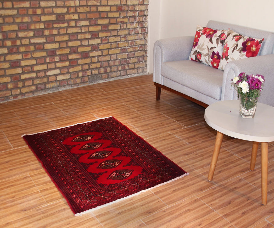 Vintage Turkmen Persian rug 104x145 cm styled in interior setting showing deep red geometric design
