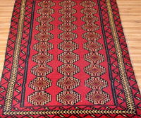 Close-up of Turkmen Persian rug showing detailed repeating gul motifs and intricate borders
