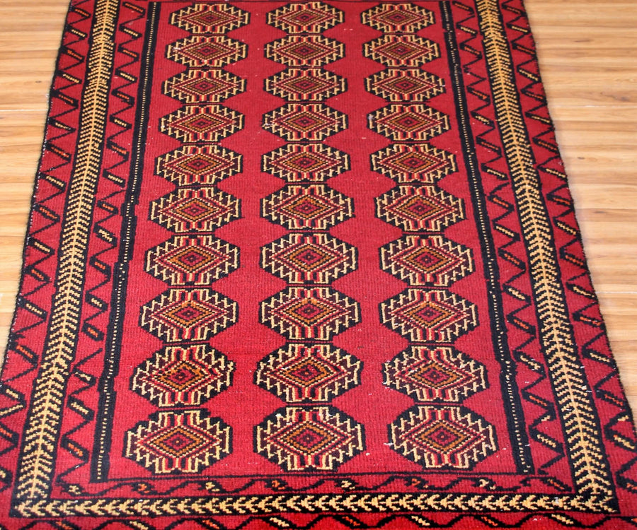 Close-up of Turkmen Persian rug showing detailed repeating gul motifs and intricate borders

