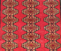Detailed view of Turkmen runner field with diamond shaped tribal medallions in red, gold and black tones

