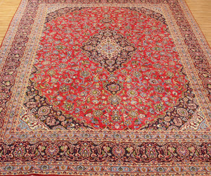 Vintage Mashad rug with grand medallion design and dense floral motifs in red, navy and ivory tones
