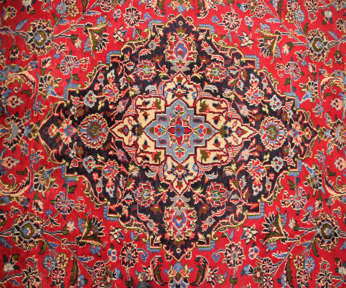 Close-up of Mashad Persian rug central medallion with detailed floral arabesque pattern
