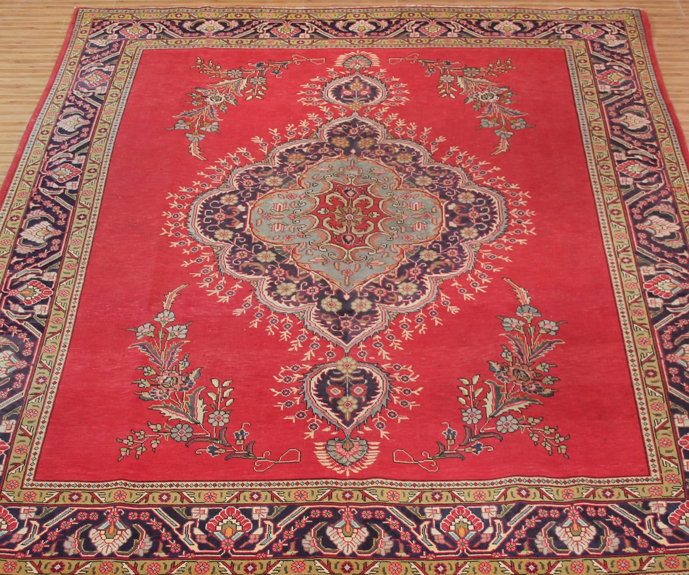 Vintage Tabriz rug with ornate medallion and delicate floral motifs in red, ivory and blue tones
