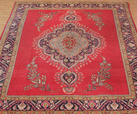 Vintage Tabriz rug with ornate medallion and delicate floral motifs in red, ivory and blue tones
