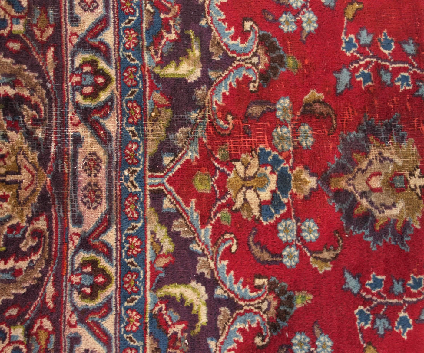 Detailed field view of vintage Mashad rug highlighting rich red background and symmetrical floral layout
