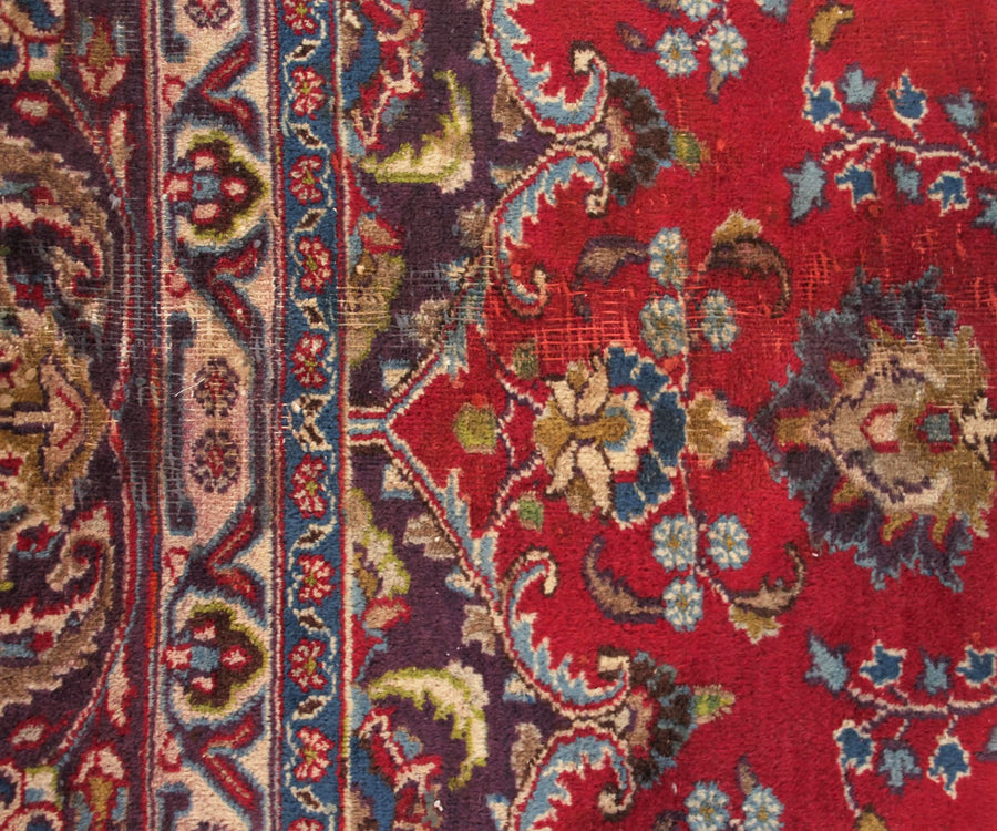 Detailed field view of vintage Mashad rug highlighting rich red background and symmetrical floral layout
