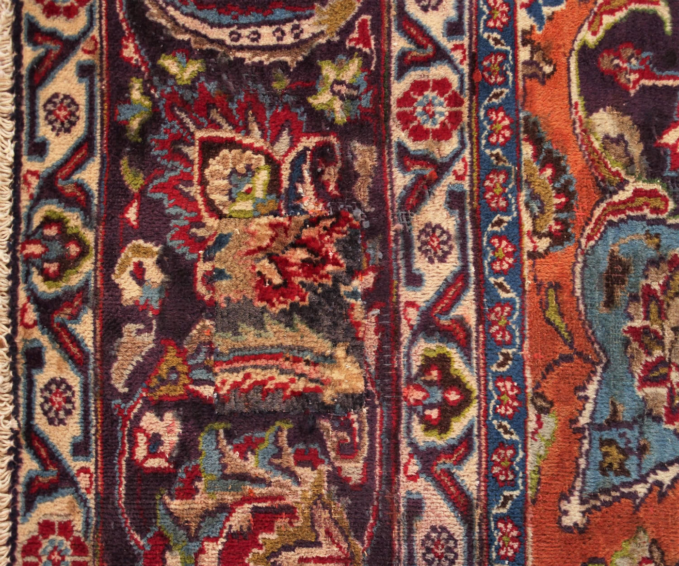Corner detail of vintage Mashad Persian rug showing classic floral pattern and decorative framing border
