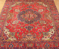 Vintage Tabriz rug featuring elaborate medallion and dense floral arabesque motifs in red, navy and ivory tones
