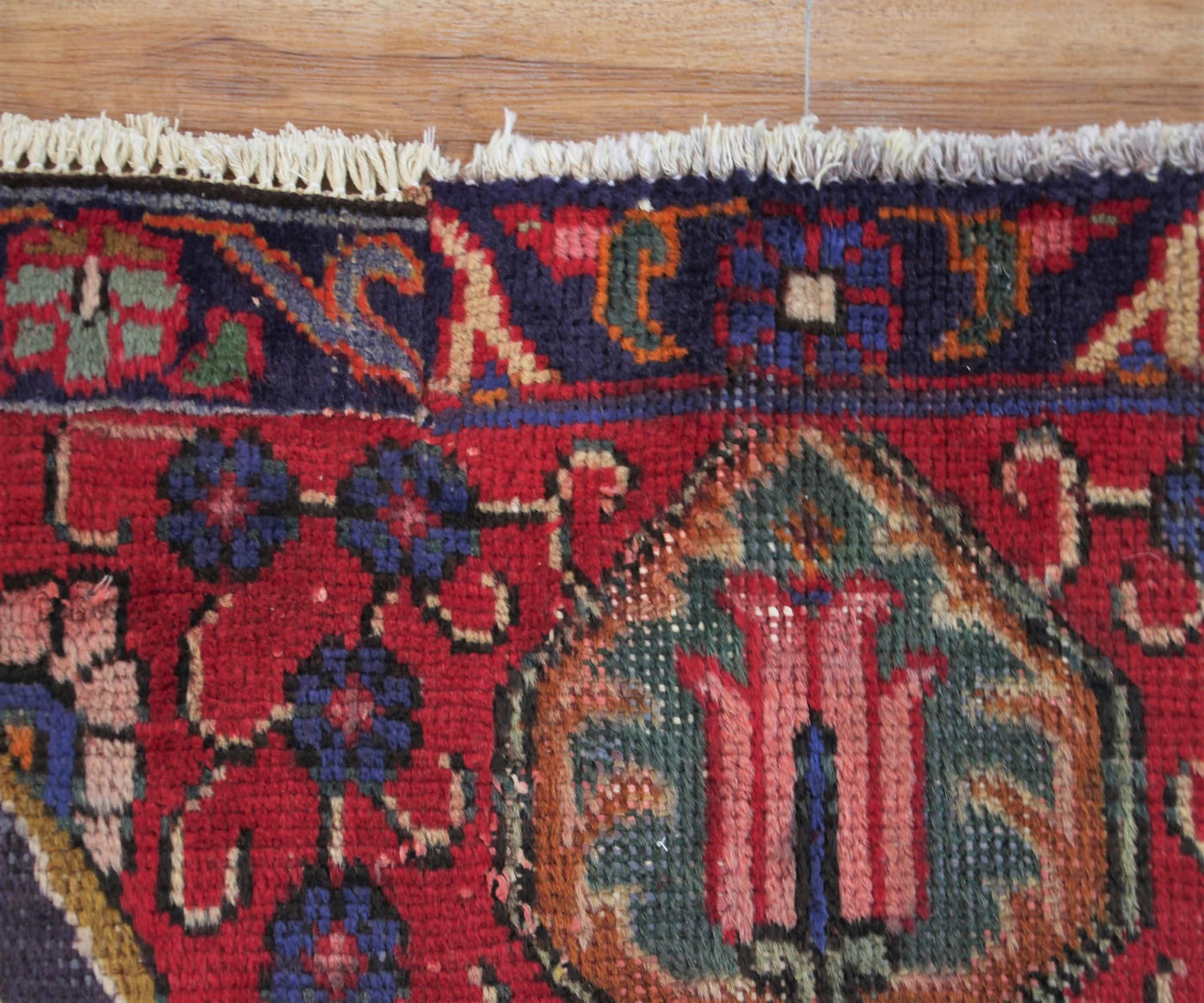 Corner detail of hand knotted Tabriz Persian rug highlighting intricate floral pattern and framing border
