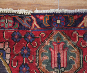 Corner detail of hand knotted Tabriz Persian rug highlighting intricate floral pattern and framing border
