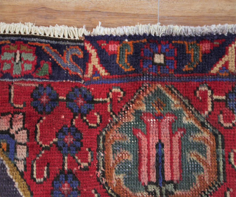 Corner detail of hand knotted Tabriz Persian rug highlighting intricate floral pattern and framing border
