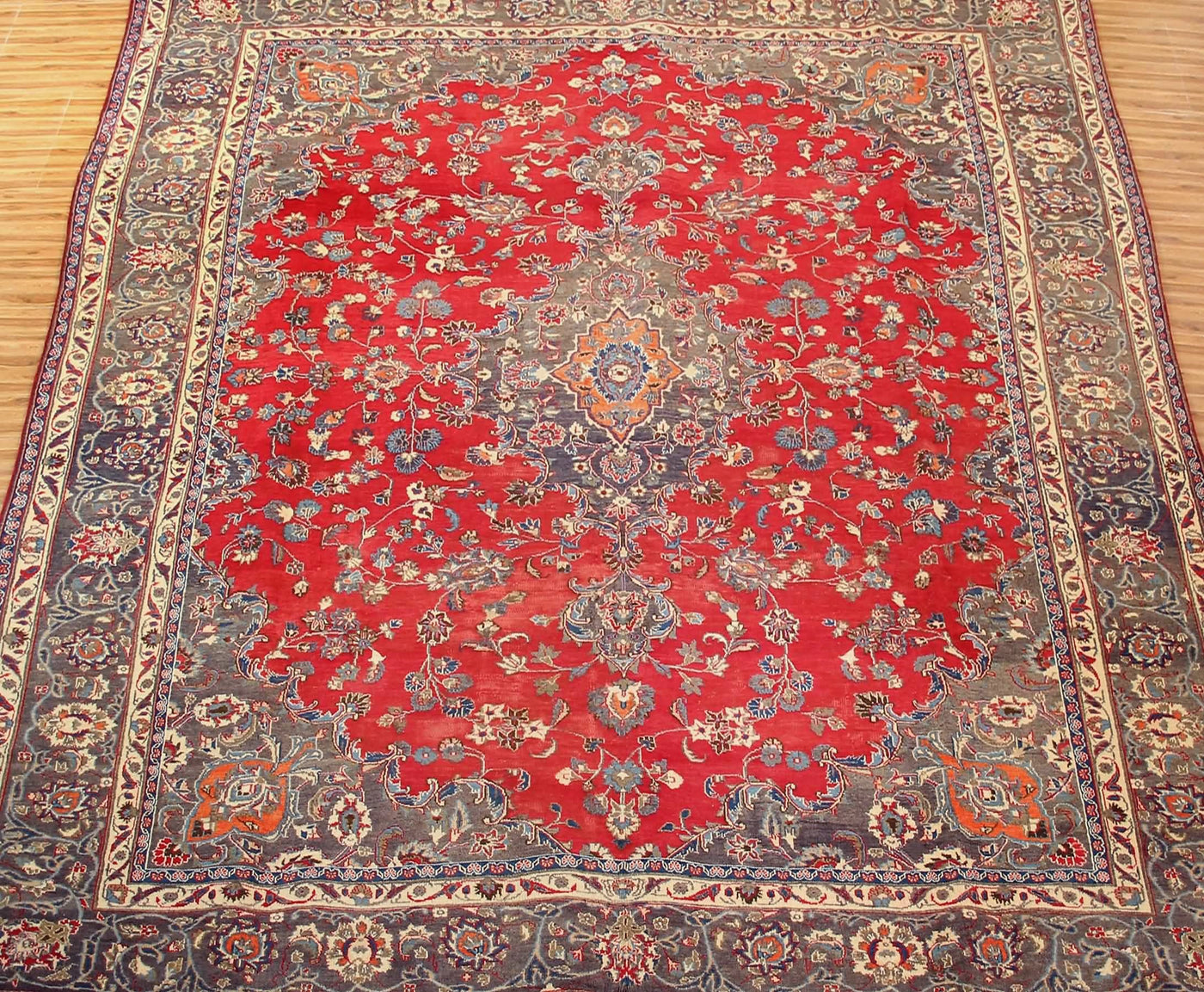Vintage Mashad rug featuring elaborate medallion and dense floral vine motifs in red, navy and ivory tones
