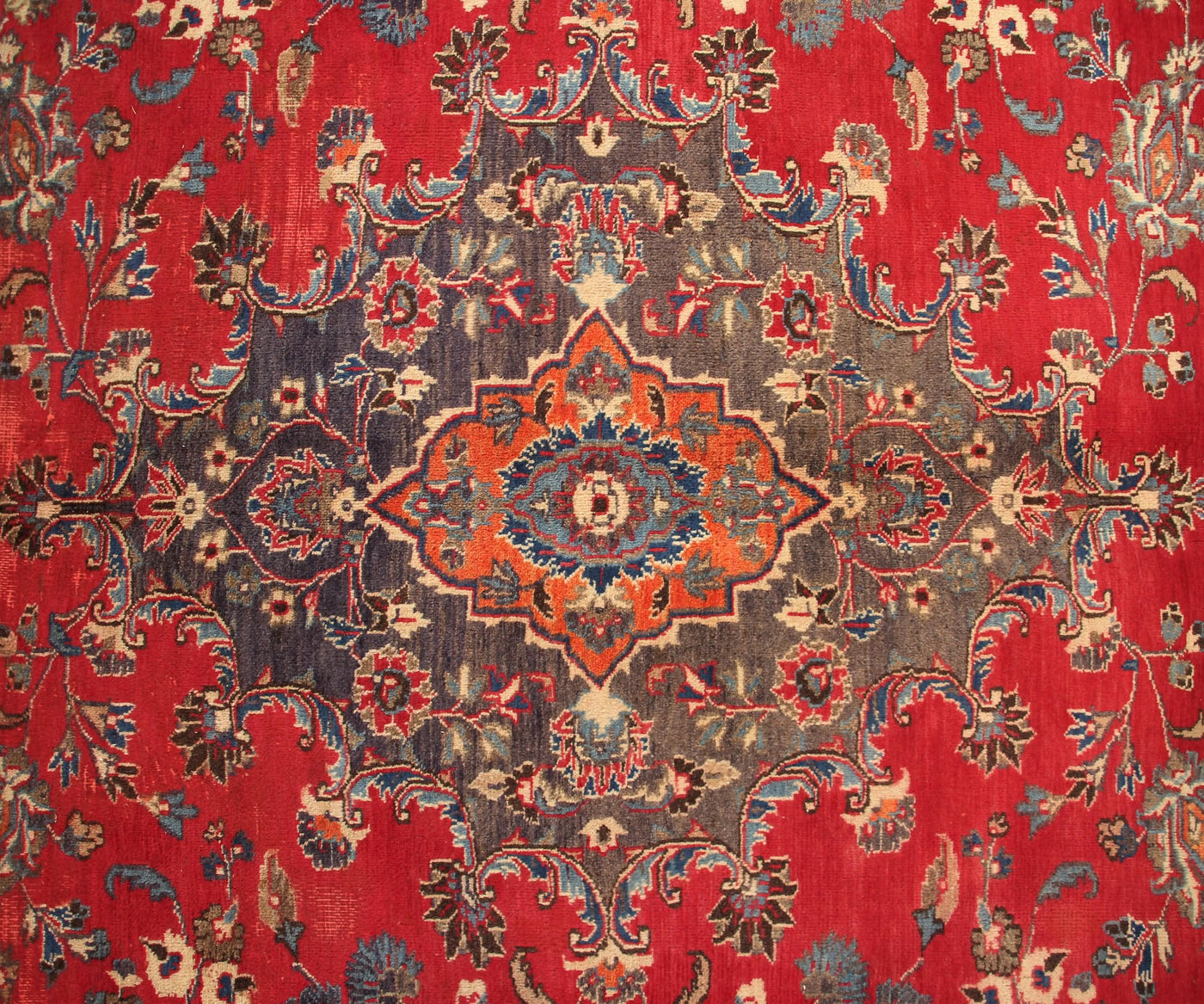 Vintage Mashad rug featuring elaborate medallion and dense floral vine motifs in red, navy and ivory tones
