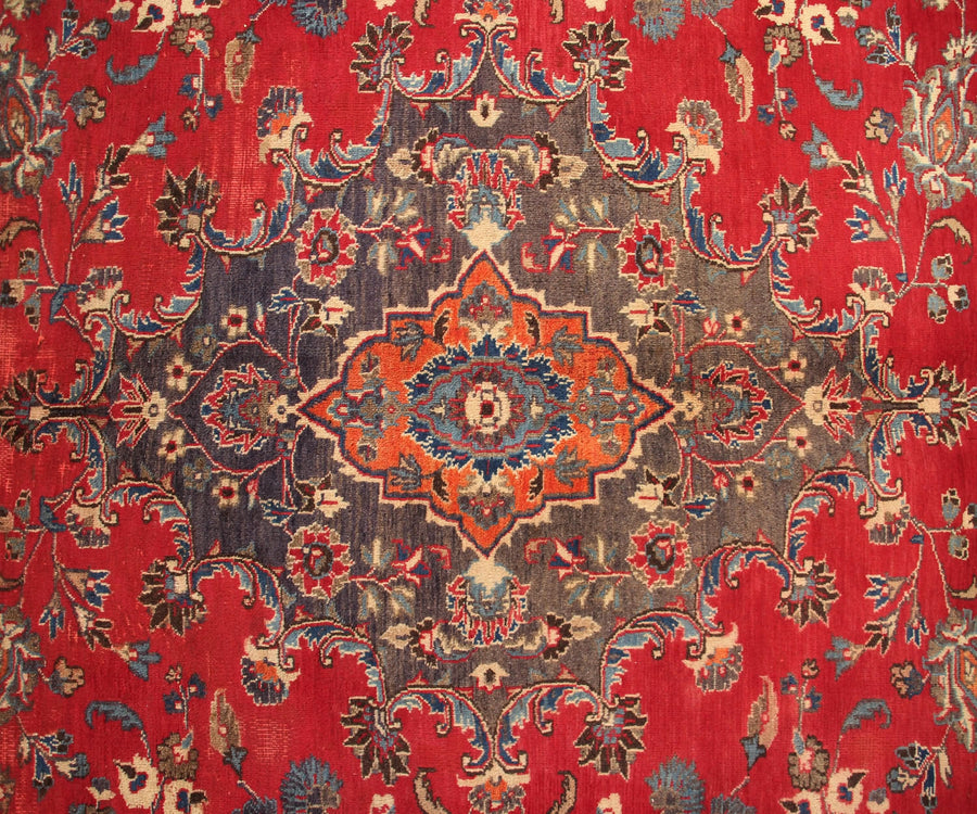 Vintage Mashad rug featuring elaborate medallion and dense floral vine motifs in red, navy and ivory tones
