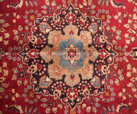 Detailed field view of antique Sabzevar rug highlighting symmetrical floral layout on deep red background
