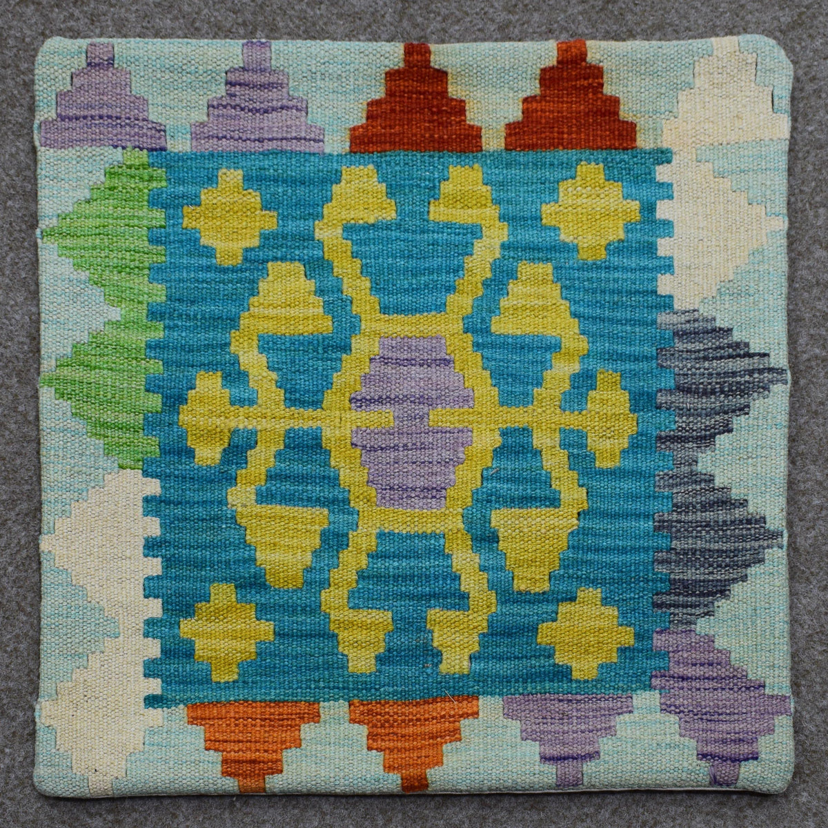 Hand woven cushion cover 45x45 cm with colorful geometric tribal pattern in turquoise, yellow and purple