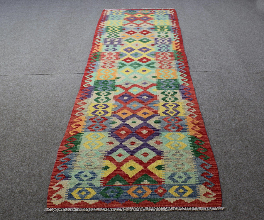 Chobi kilim runner 83x385 cm full view showing vibrant tribal motifs in red, green, yellow and blue

