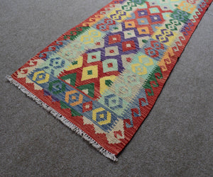 Angled view of tribal Chobi kilim runner showing flatweave structure and clean finished edges
