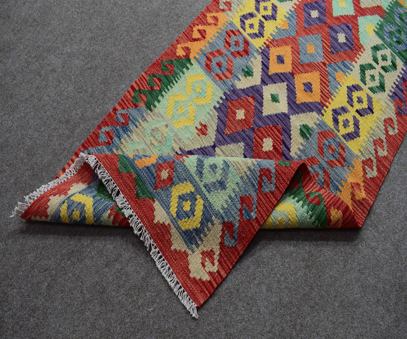 Folded view of Chobi kilim runner showing authentic flatwoven construction and fringe detail
