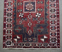 Detailed view of Shiraz rug field with stylized tribal motifs and rich red wool texture
