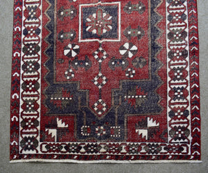 Detailed view of Shiraz rug field with stylized tribal motifs and rich red wool texture
