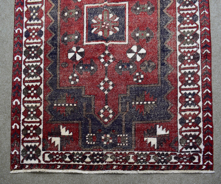Detailed view of Shiraz rug field with stylized tribal motifs and rich red wool texture
