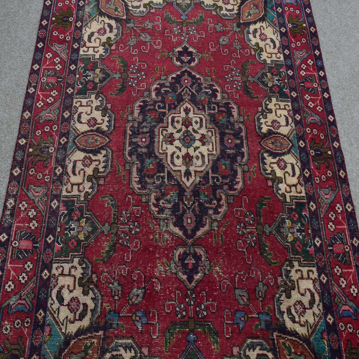 Close-up of central medallion on vintage Persian Shiraz rug with navy, ivory and red detailing