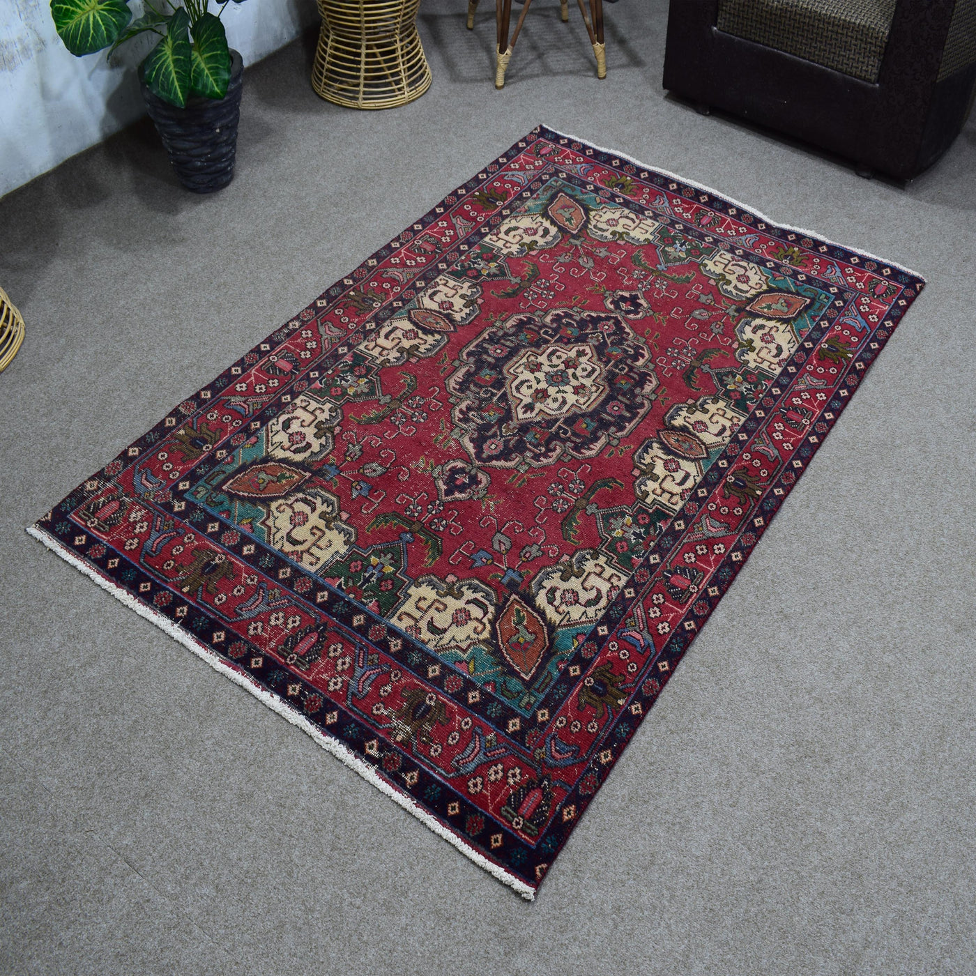 Angled view of hand knotted Shiraz rug highlighting rich red tones and tribal floral motifs
