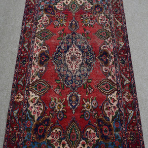 Close-up of central medallion on Shiraz rug with navy, ivory and light blue detailing