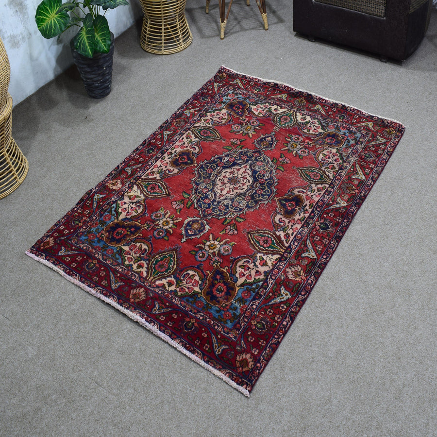 Angled perspective of vintage Shiraz rug highlighting rich red tones and intricate floral motifs