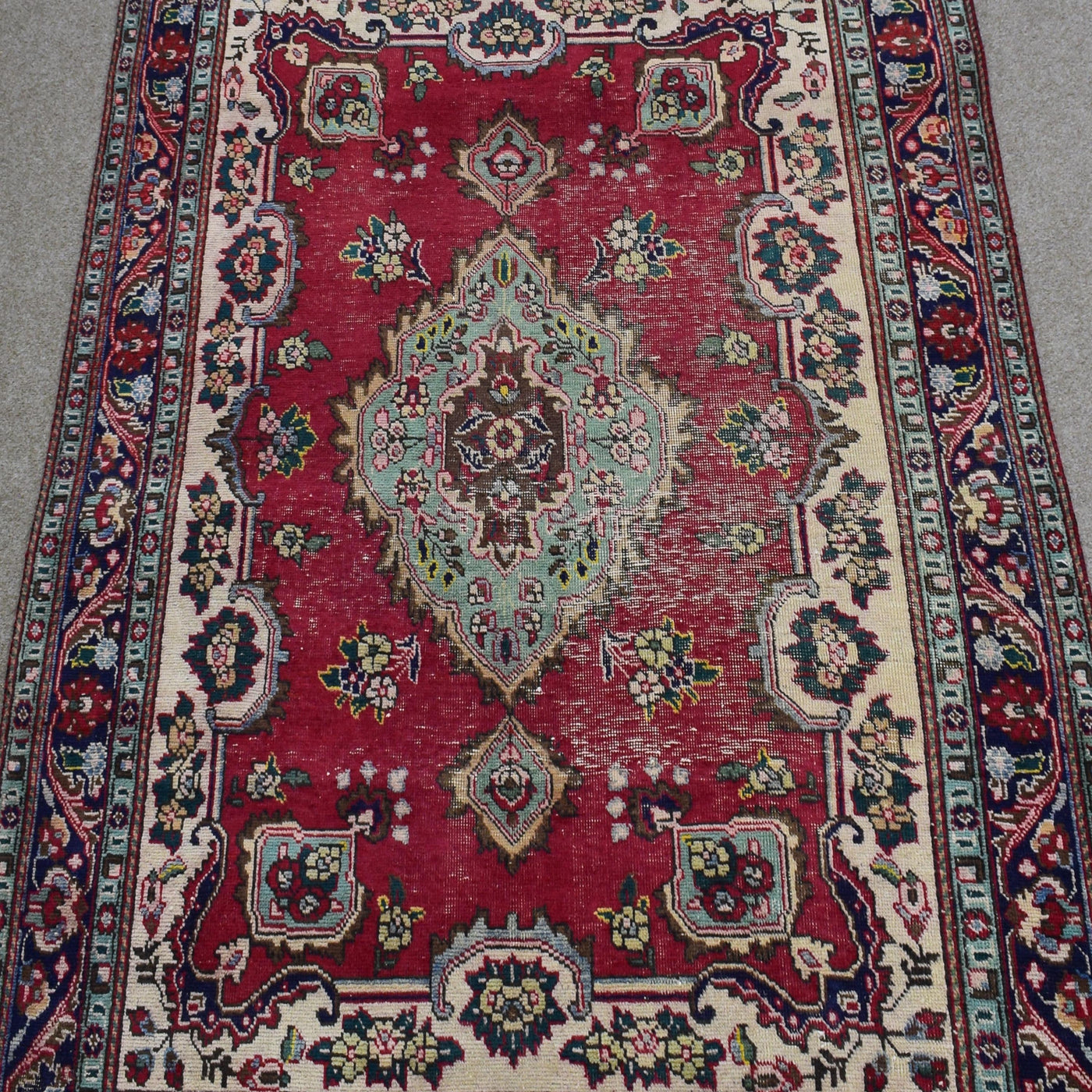 Close-up of central medallion on Shiraz rug with mint green, ivory and navy detailing