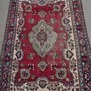 Close-up of central medallion on Shiraz rug with mint green, ivory and navy detailing
