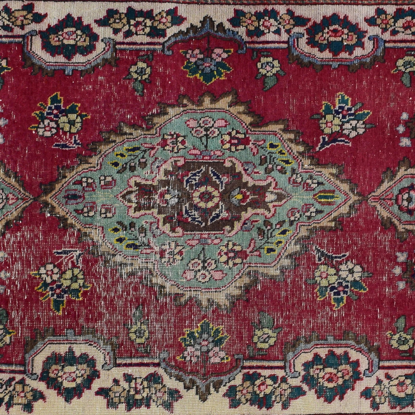 Detailed view of elongated medallion on red Shiraz rug with floral motifs and soft abrash