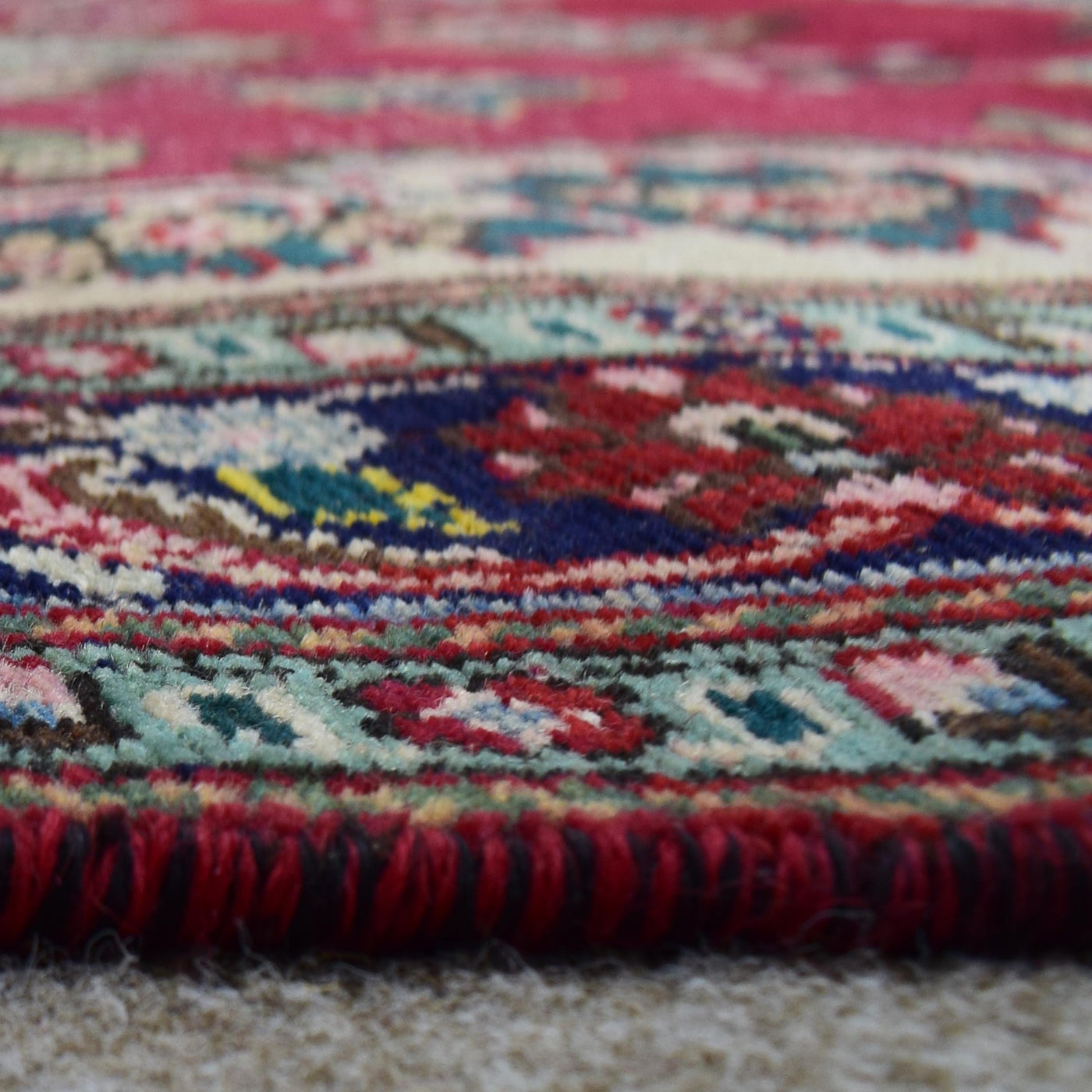 Low angle close-up of Shiraz rug pile showing thick wool texture and colorful pattern definition