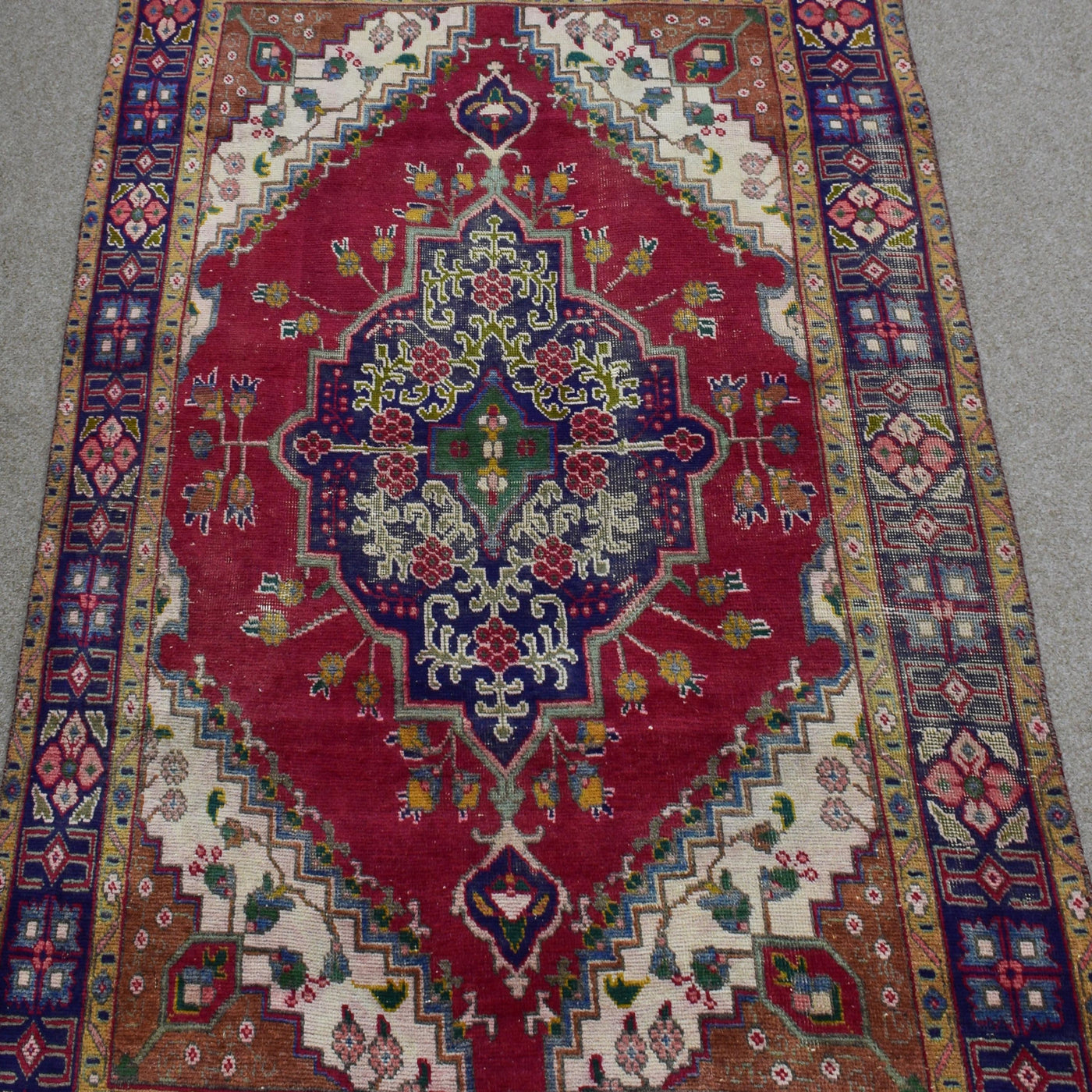 Close-up of central medallion on Shiraz rug with navy, green and ivory floral detailing
