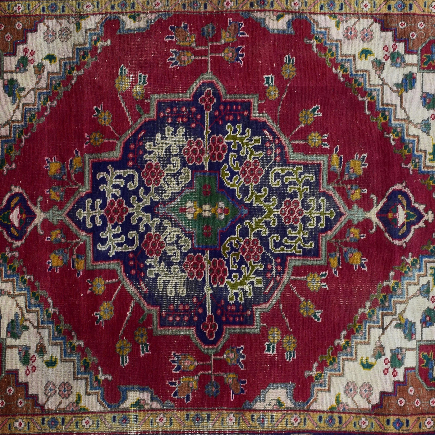 Detailed view of geometric medallion on red Shiraz rug with intricate tribal motifs