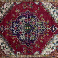 Detailed view of geometric medallion on red Shiraz rug with intricate tribal motifs