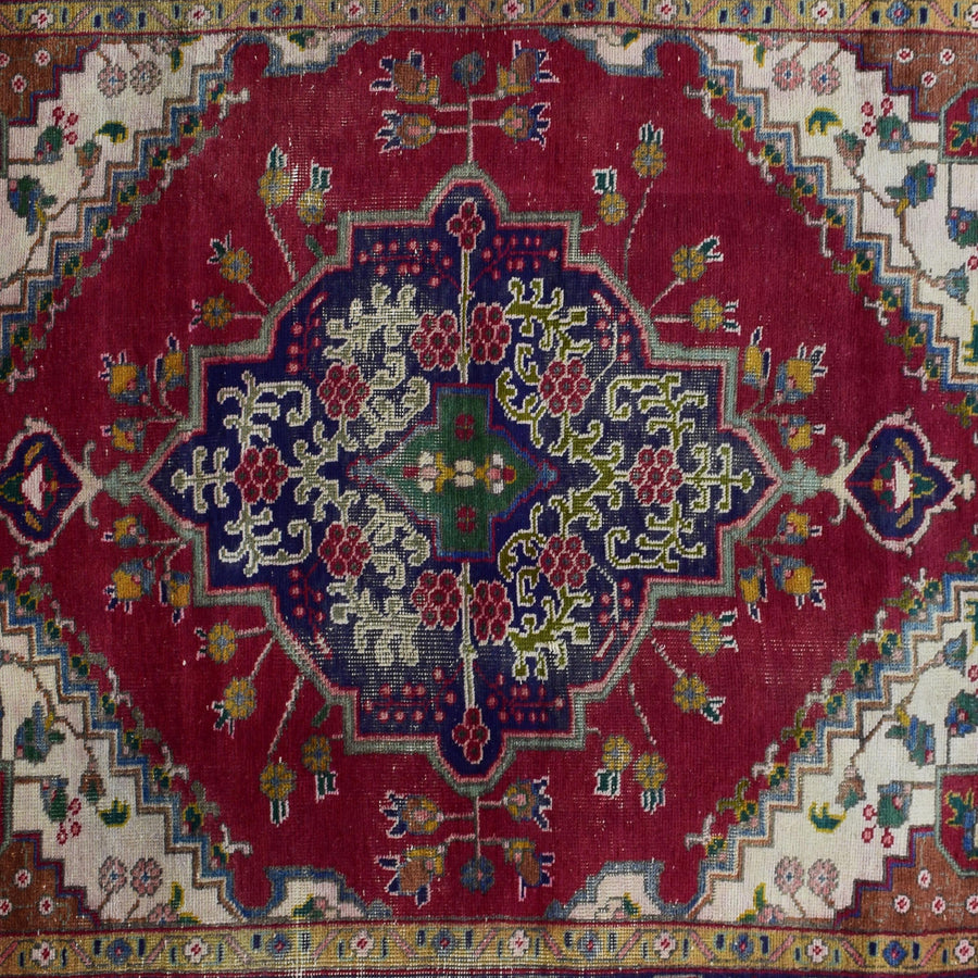 Detailed view of geometric medallion on red Shiraz rug with intricate tribal motifs