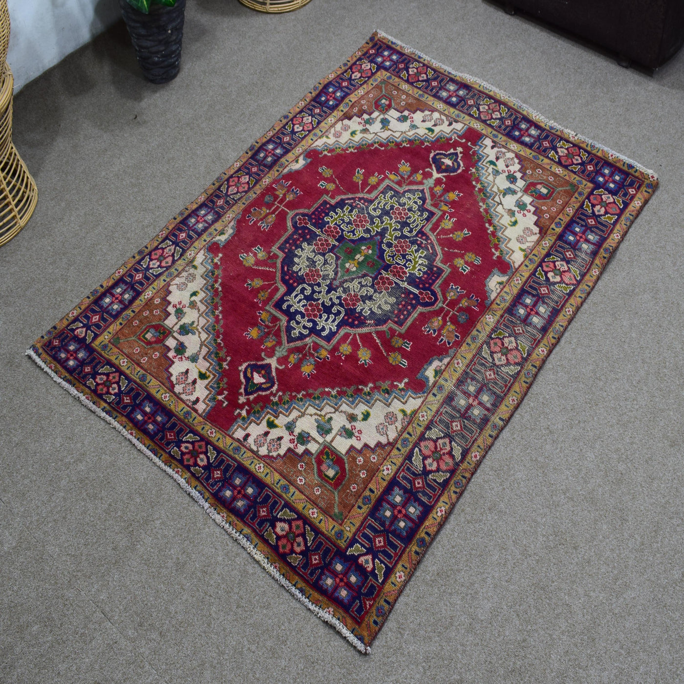 Angled view of vintage Shiraz rug highlighting deep blue medallion and vibrant red background