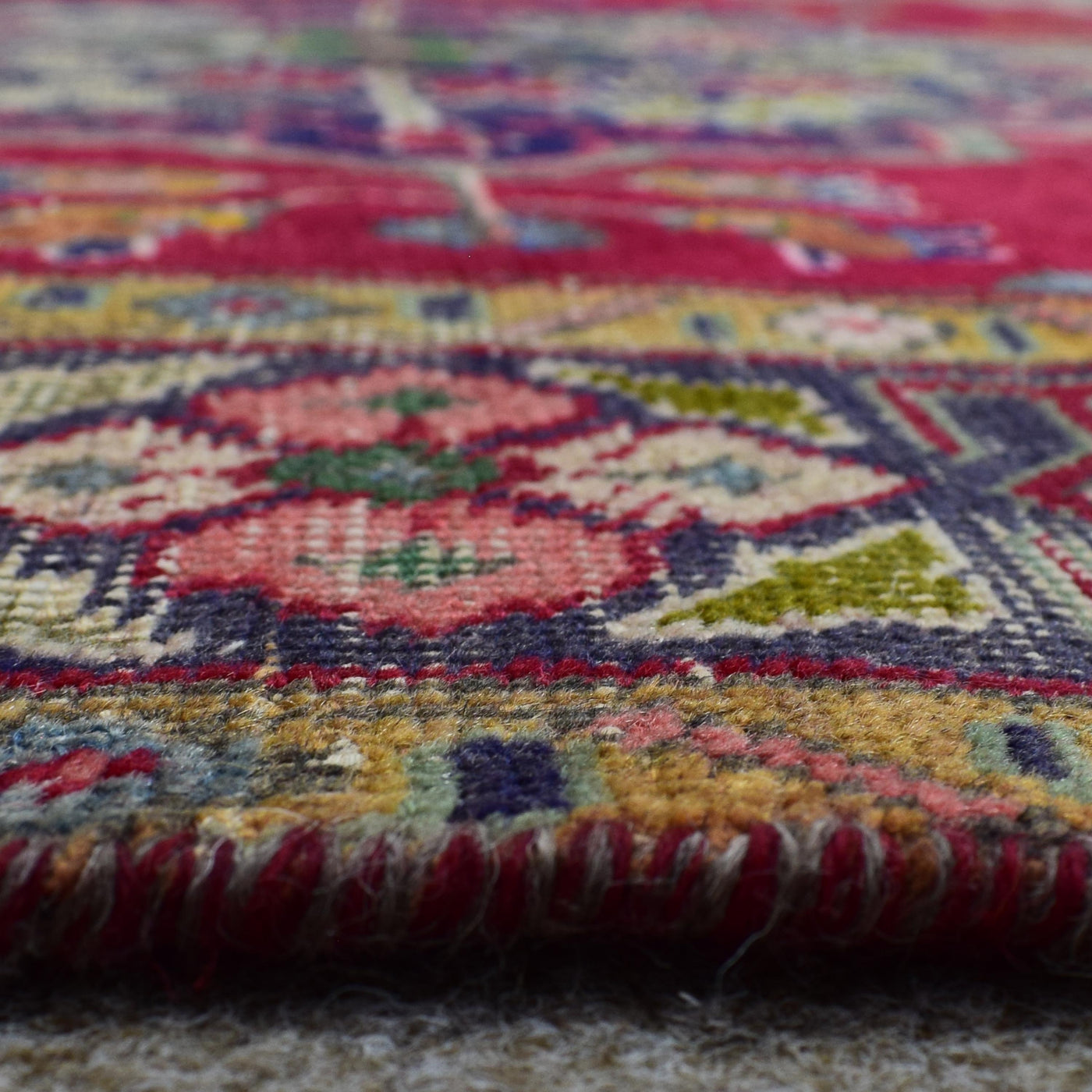 Low angle close-up of Shiraz rug pile showing dense wool texture and vivid color contrast