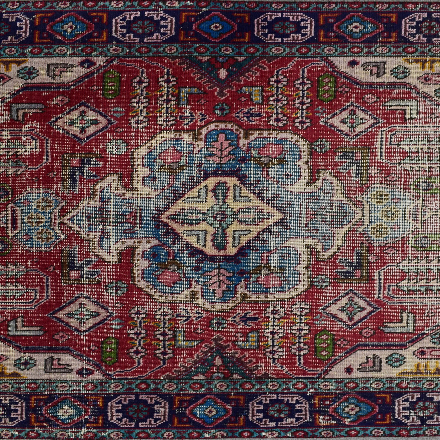 Detailed view of red field with tribal motifs and stepped diamond shapes