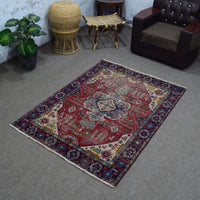 Angled room view of vintage Shiraz rug displaying full proportions and border design