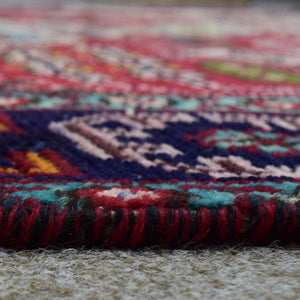 Low angle close-up of Shiraz rug pile showing thick wool texture and vibrant blue accents