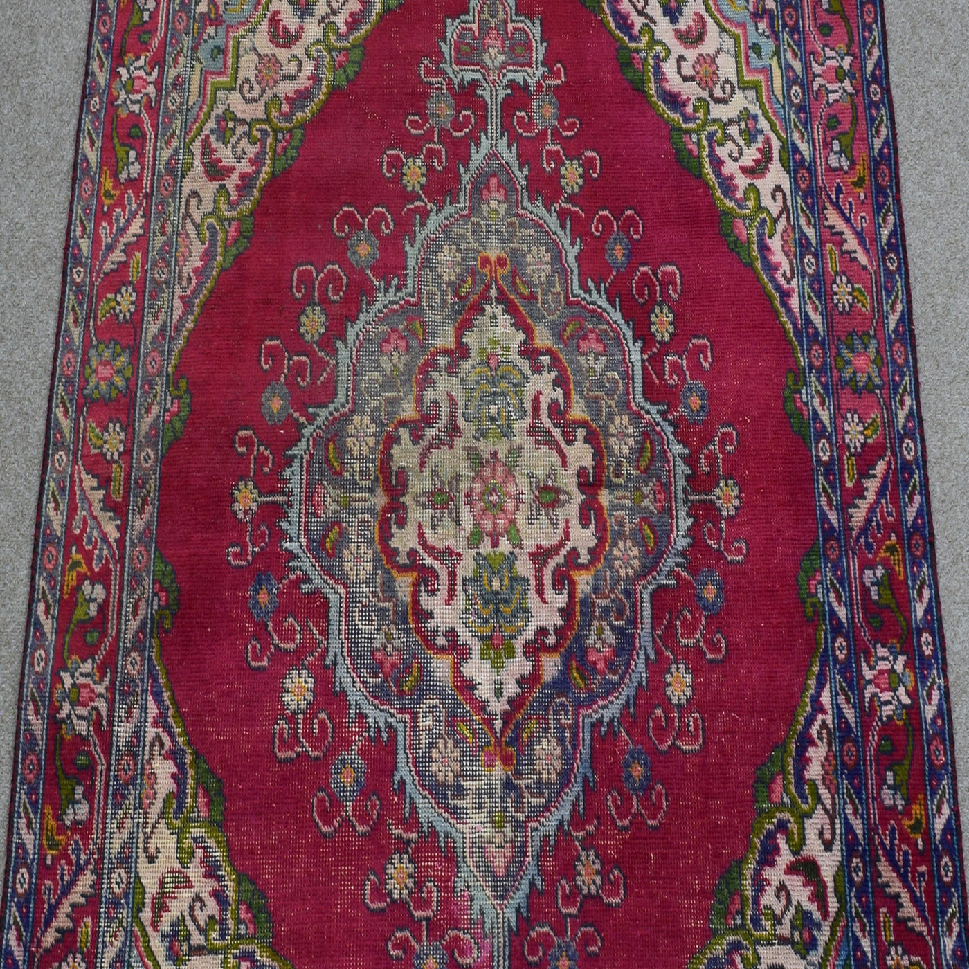 Close-up of central medallion on Shiraz rug with ivory, navy and soft blue floral detailing