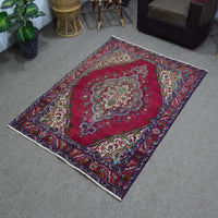 Angled perspective of vintage Shiraz rug highlighting rich red tones and detailed border design