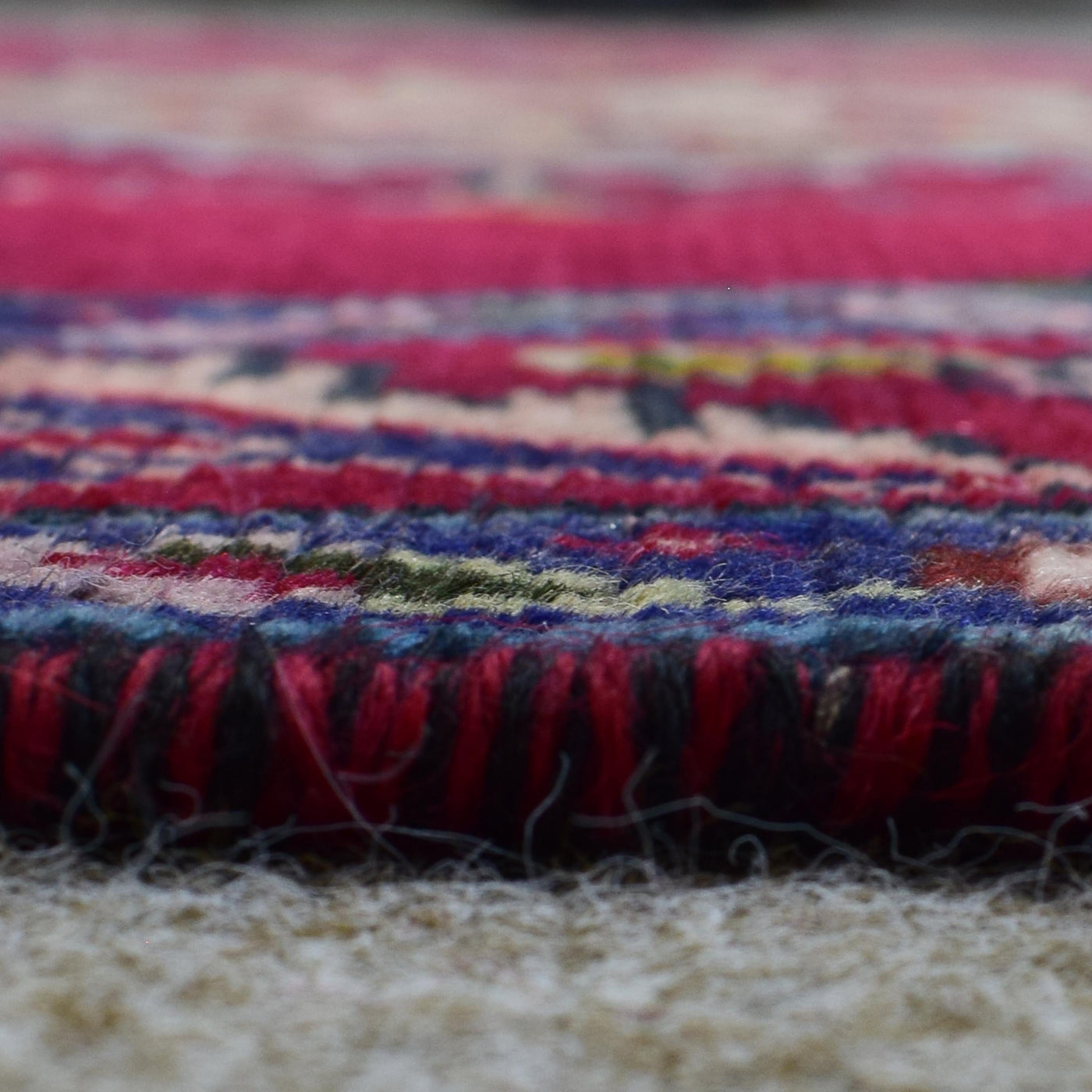 Low angle close-up of Shiraz rug pile showing thick wool texture and vibrant color variation