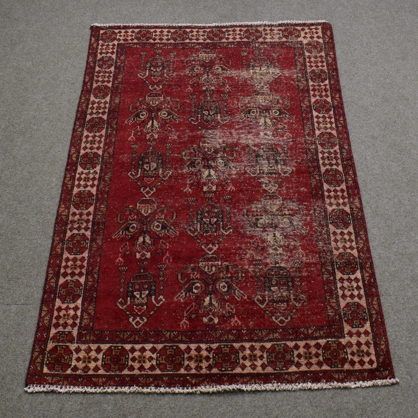 Full length view of Shiraz rug 118x188 cm showing worn red background and subtle geometric medallions