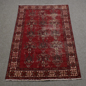 Full length view of Shiraz rug 118x188 cm showing worn red background and subtle geometric medallions